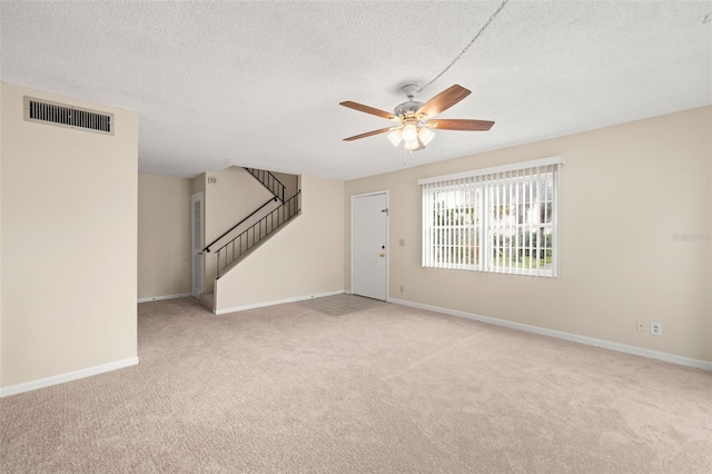 carpeted empty room with a textured ceiling and ceiling fan