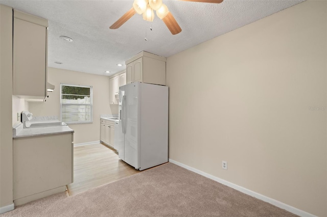 kitchen with white refrigerator with ice dispenser, light carpet, ceiling fan, stove, and a textured ceiling