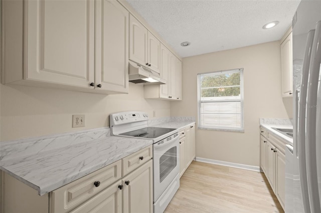 kitchen featuring light stone countertops, electric range, light hardwood / wood-style floors, and a textured ceiling