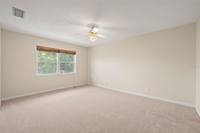 empty room with light colored carpet, a textured ceiling, and ceiling fan