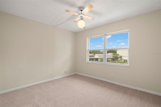 carpeted spare room with ceiling fan and a textured ceiling