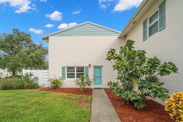 property entrance with a lawn