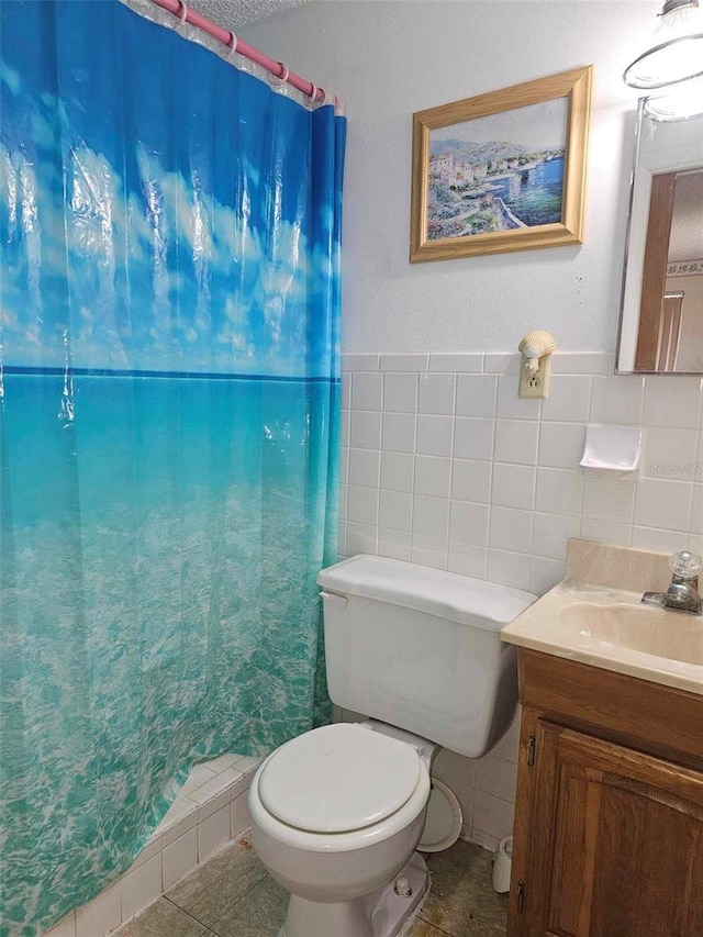 bathroom with tile walls, backsplash, tile patterned floors, toilet, and vanity