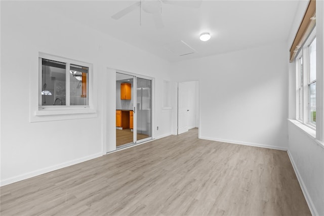 empty room with ceiling fan and light hardwood / wood-style floors