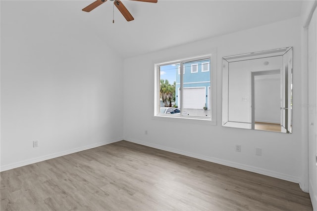 empty room with lofted ceiling, light hardwood / wood-style flooring, and ceiling fan