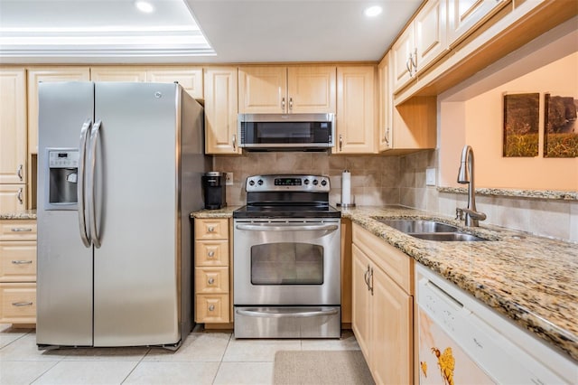 kitchen featuring appliances with stainless steel finishes, light brown cabinetry, sink, light tile patterned floors, and decorative backsplash