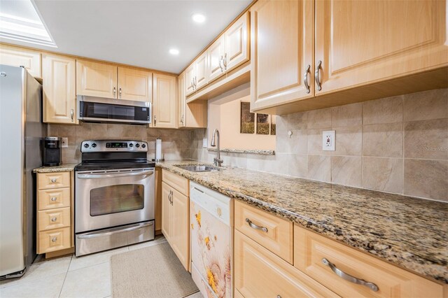 kitchen with appliances with stainless steel finishes, sink, and decorative backsplash