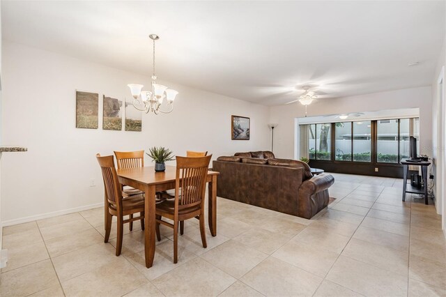 tiled dining area with ceiling fan with notable chandelier