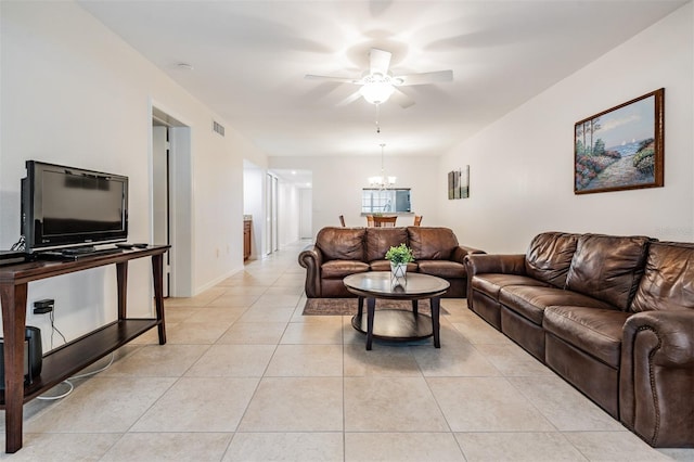 living room with light tile patterned flooring and ceiling fan with notable chandelier