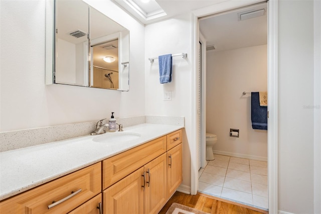 bathroom with vanity, toilet, and hardwood / wood-style floors