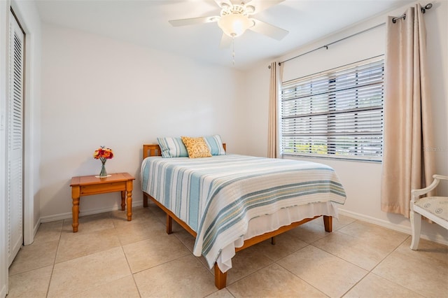 tiled bedroom featuring ceiling fan and a closet