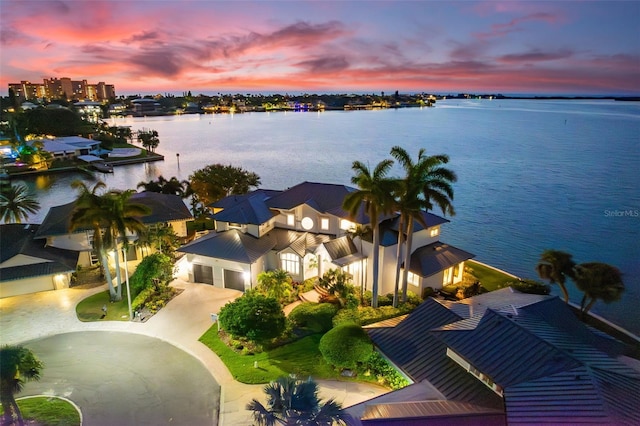 aerial view at dusk featuring a water view