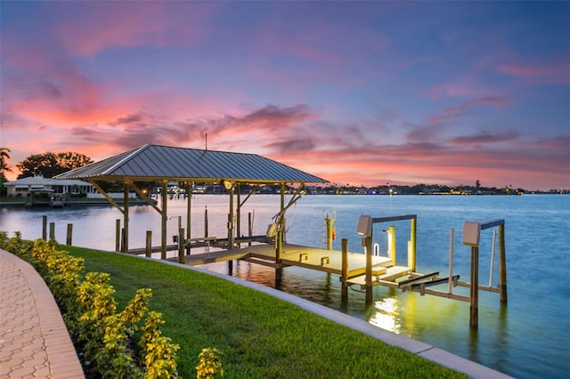 view of dock with a yard and a water view