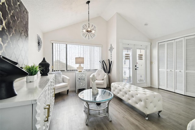 interior space with an inviting chandelier, hardwood / wood-style flooring, high vaulted ceiling, and french doors