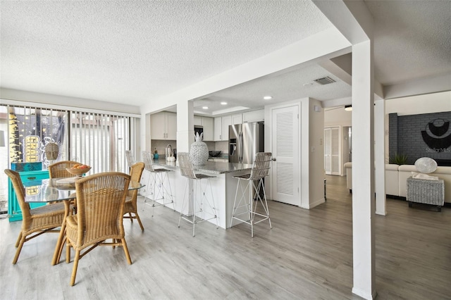 dining area featuring hardwood / wood-style floors and a textured ceiling