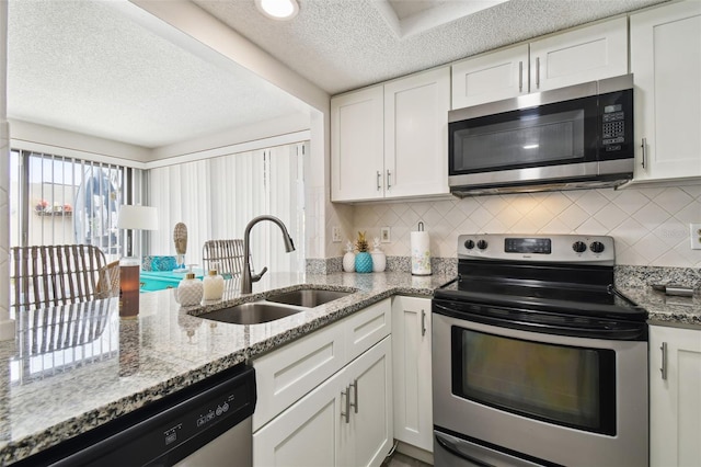 kitchen with white cabinetry, appliances with stainless steel finishes, sink, and tasteful backsplash