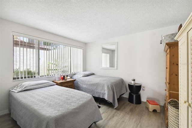 bedroom featuring light hardwood / wood-style flooring and a textured ceiling