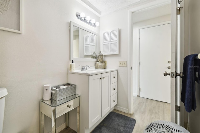 bathroom featuring vanity, a textured ceiling, toilet, and hardwood / wood-style flooring