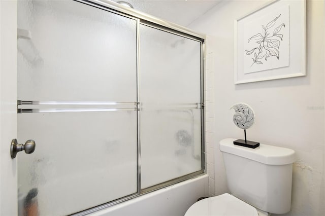 bathroom with combined bath / shower with glass door and toilet