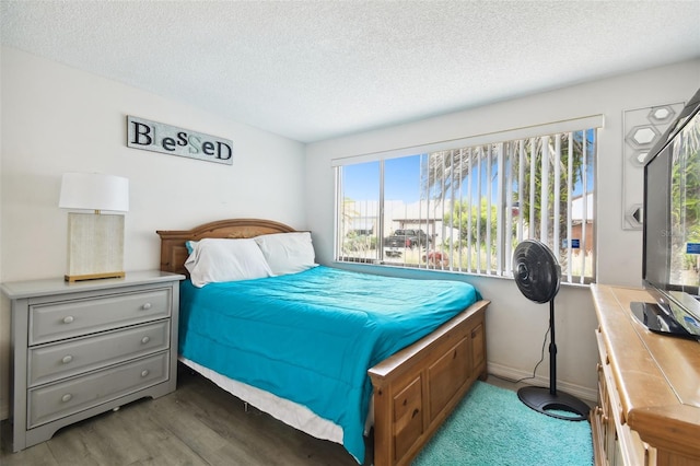 bedroom with dark hardwood / wood-style floors and a textured ceiling