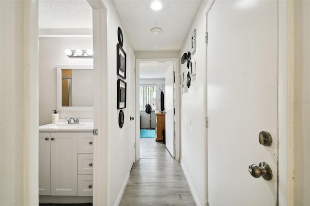 corridor featuring sink and light hardwood / wood-style floors