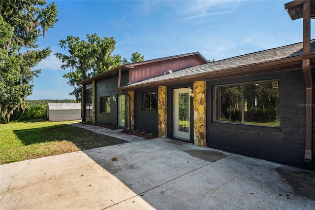 back of property with a patio area and a lawn