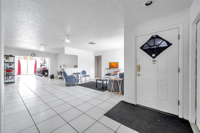 foyer entrance featuring light tile patterned flooring and a textured ceiling