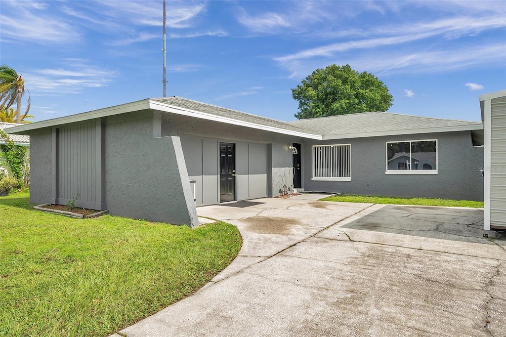 back of property featuring stucco siding, a patio area, and a yard