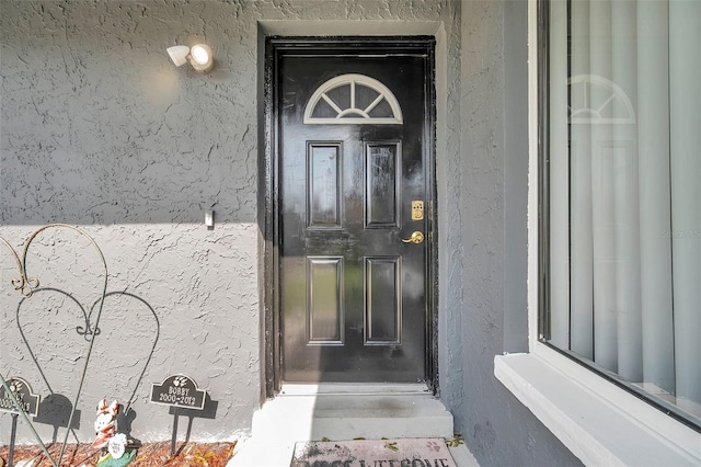 doorway to property featuring stucco siding