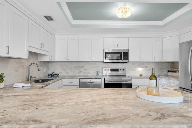 kitchen featuring white cabinetry, stainless steel appliances, and decorative backsplash