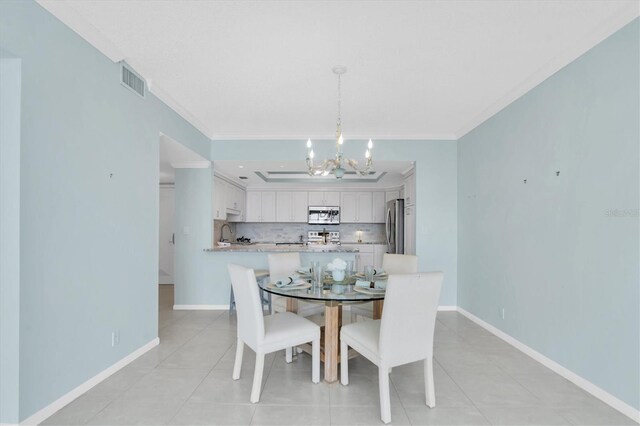 tiled dining area featuring a notable chandelier and crown molding