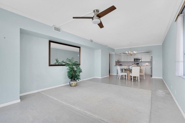 unfurnished living room with light tile patterned flooring, ceiling fan with notable chandelier, and crown molding