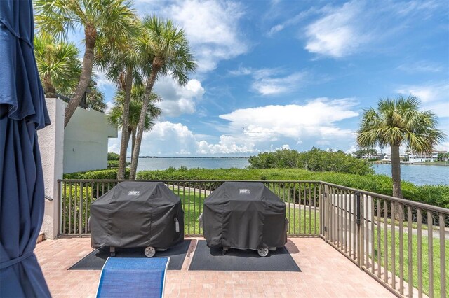 view of patio / terrace featuring a balcony, a water view, and area for grilling