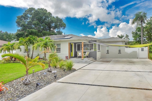 ranch-style house with a front yard and solar panels