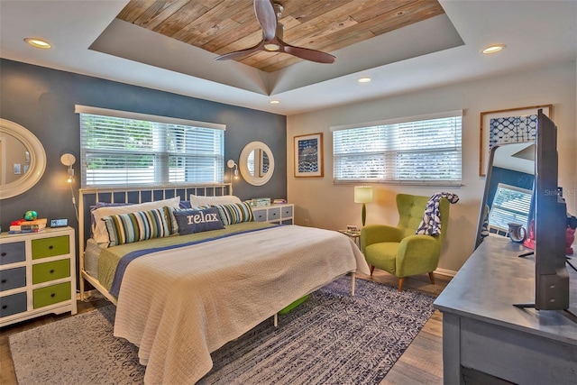 bedroom with ceiling fan, wooden ceiling, wood-type flooring, and a tray ceiling