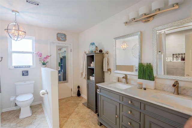 bathroom with tile patterned flooring, dual vanity, a notable chandelier, and toilet