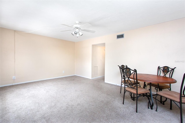 carpeted dining area with ceiling fan, visible vents, and baseboards