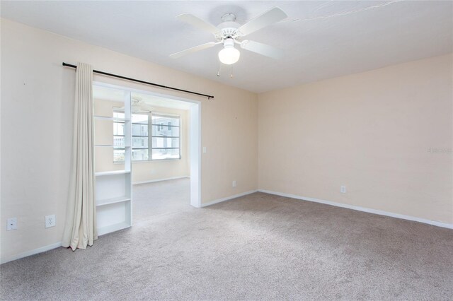 spare room with light colored carpet and ceiling fan