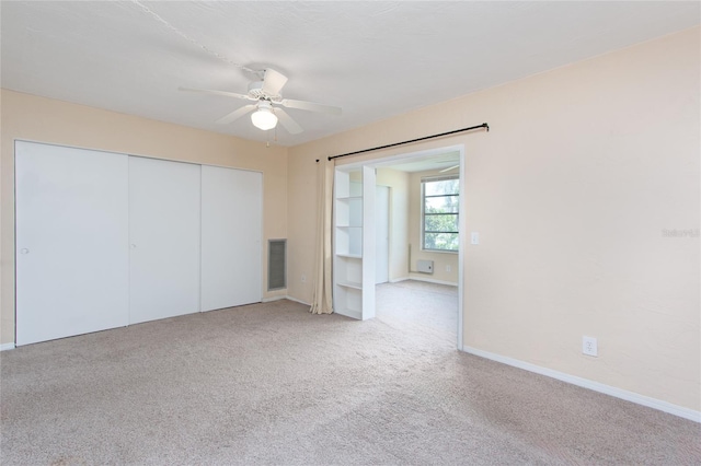 unfurnished bedroom with carpet floors, ceiling fan, visible vents, and a closet