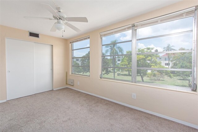 unfurnished bedroom with light colored carpet, a closet, and ceiling fan