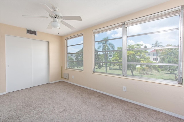 unfurnished bedroom with ceiling fan, carpet flooring, visible vents, baseboards, and a closet