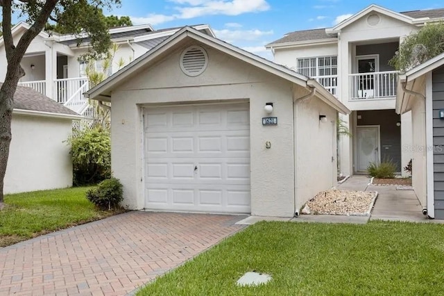 view of front of home with a balcony, a garage, and a front lawn