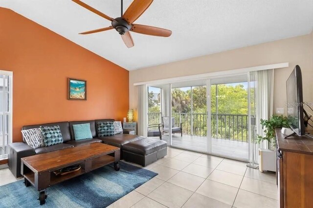 living room with light tile patterned flooring, vaulted ceiling, and ceiling fan