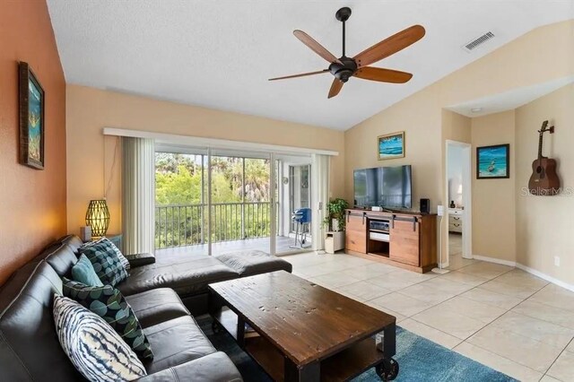 tiled living room featuring ceiling fan and vaulted ceiling