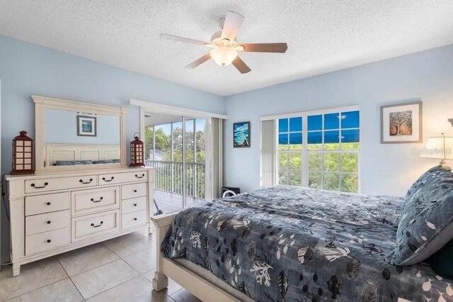 bedroom featuring ceiling fan, light tile patterned floors, access to exterior, and a textured ceiling