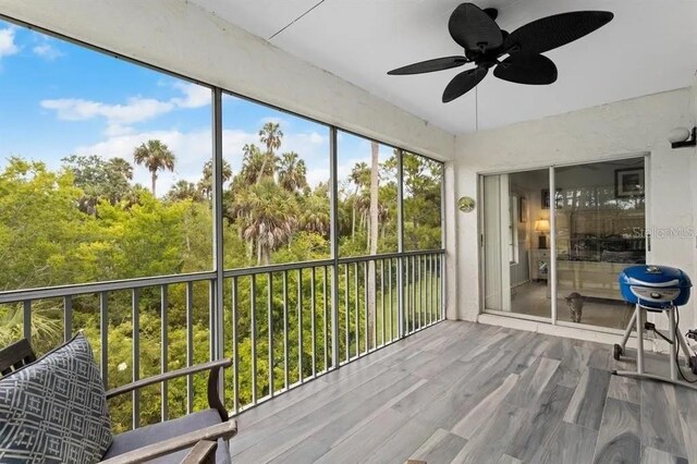 unfurnished sunroom featuring ceiling fan