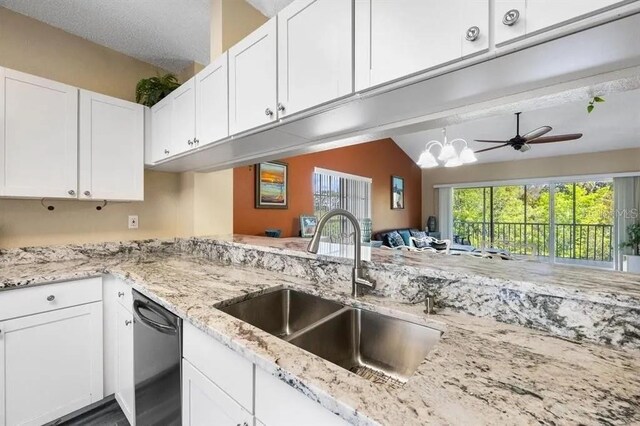 kitchen featuring ceiling fan with notable chandelier, dishwasher, white cabinetry, sink, and kitchen peninsula