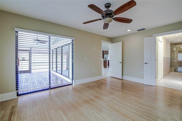 empty room with ceiling fan and light hardwood / wood-style floors