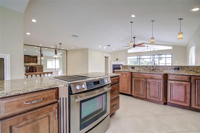 kitchen with vaulted ceiling, light tile patterned floors, sink, stainless steel range oven, and ceiling fan