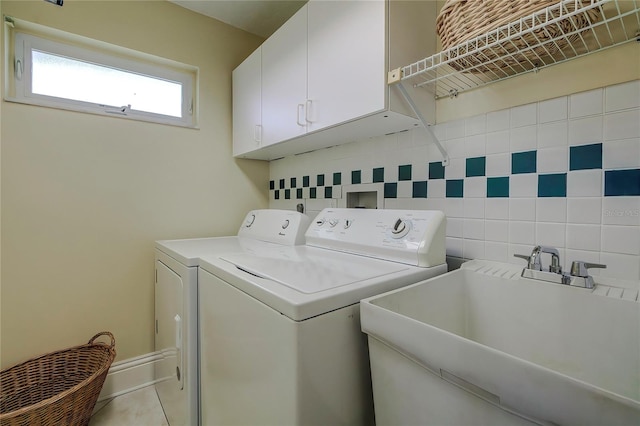 laundry room featuring separate washer and dryer, light tile patterned floors, cabinets, and sink